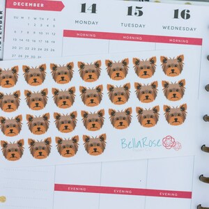 May include: A sheet of 18 brown and black Yorkshire Terrier dog stickers. The stickers are arranged in a grid pattern on a white background. The stickers are approximately 1 inch in diameter.