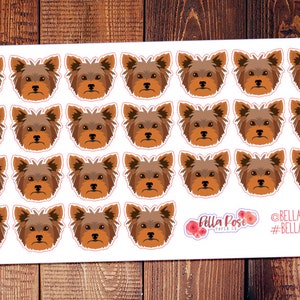 May include: A sheet of 24 brown and white Yorkshire Terrier dog stickers. The stickers are arranged in four rows of six stickers each. The stickers are on a white background. The text "Bella Rose Paper Co." and "#bellarosepaperco" is in the bottom right corner of the sheet.