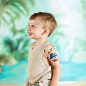 Boy Wearing Dinosaur Temporary Tattoos Set. Dino Birthday Party Activity and Favors.