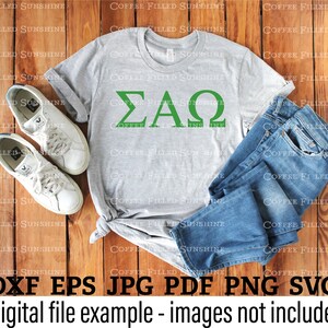 May include: A gray t-shirt with the Greek letters "&Sigma;&Alpha;&Omega;" in green on the front. The t-shirt is laid out on a wooden surface with a pair of white sneakers and blue jeans.