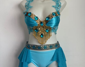 May include: A blue and gold costume set with a sequined and jeweled bra top and a matching skirt with a ruffled hem.