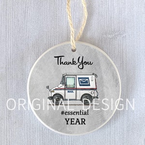Op de afbeelding: Witte keramische ornament met een tekening van een postwagen en de tekst "Thank You #essential YEAR".