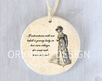 Può includere: Un ornamento rotondo in ceramica con un'illustrazione vintage di una donna in un abito blu e un cappello. L'ornamento ha uno sfondo beige e il testo "Se le avventure non capitano a una giovane donna nel suo villaggio, deve cercarle all'estero."