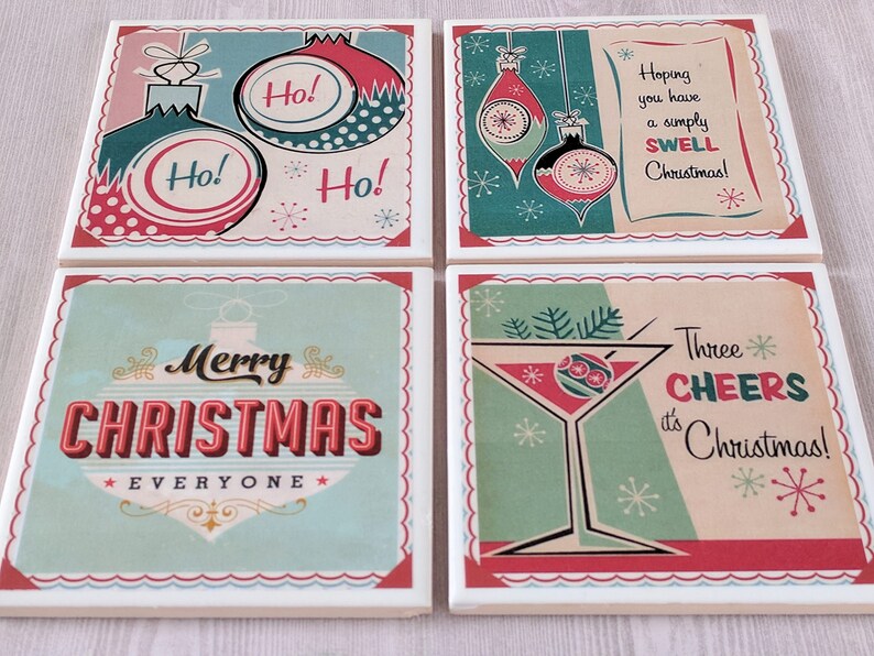 K&ouml;nnte beinhalten: Set aus vier quadratischen Untersetzern mit einem Vintage-Weihnachtsmotiv. Jeder Untersetzer zeigt ein anderes Design in den Farben Rot, Gr&uuml;n und Wei&szlig;. Die Designs beinhalten Ornamente, ein Martini-Glas und den Text "Ho!" und "Frohe Weihnachten an alle".