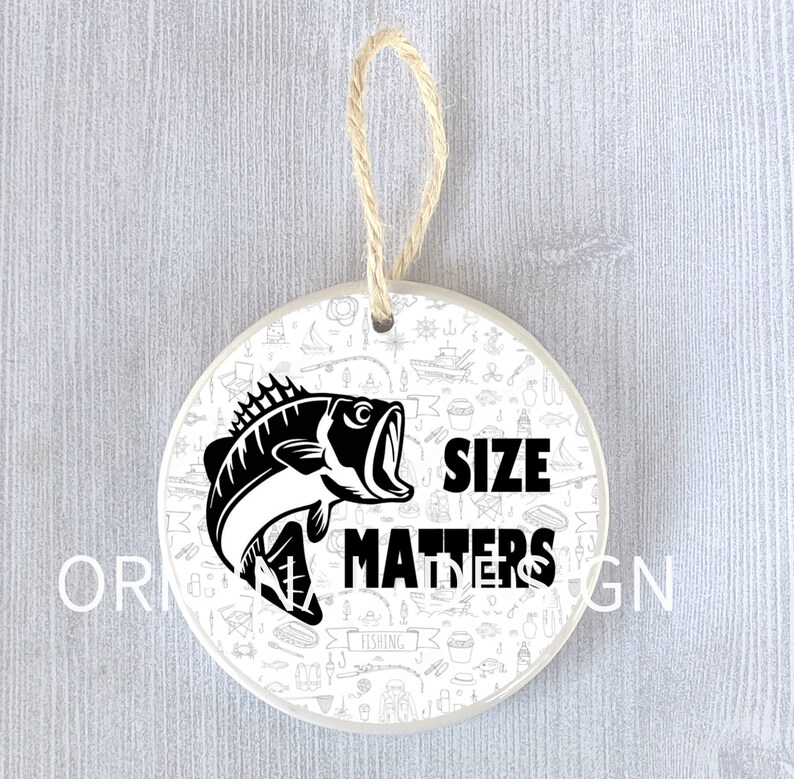 Op de afbeelding: Een witte keramische ornament met een zwart-witte illustratie van een vis en de tekst "Size Matters". De ornament is omringd door een patroon van visgerelateerde iconen.