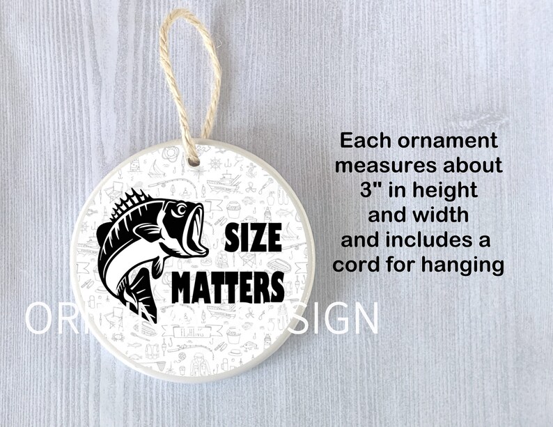 Op de afbeelding: Witte keramische ornament met een zwart-witte illustratie van een vis en de tekst "SIZE MATTERS". De ornament is 7,6 cm hoog en breed en heeft een koord om op te hangen.
