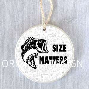 Op de afbeelding: Een witte keramische ornament met een zwart-witte illustratie van een vis en de tekst "Size Matters" op een witte achtergrond met een vis-thema.