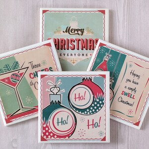 K&ouml;nnte beinhalten: Set aus vier quadratischen Untersetzern aus Keramik mit einem Vintage-Weihnachtsmotiv. Jeder Untersetzer zeigt ein anderes Design in den Farben Rot, Gr&uuml;n und Wei&szlig;. Die Designs beinhalten ein Martini-Glas mit einem Weihnachtsbaumschmuck, einen Weihnachtsbaumschmuck mit dem Wort "Ho!" darauf, einen Weihnachtsbaumschmuck mit dem Text "Frohe Weihnachten an alle" und einen Weihnachtsbaumschmuck mit dem Text "Ich hoffe, Sie haben ein einfach gro&szlig;artiges Weihnachtsfest!"