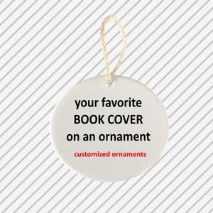 Op de afbeelding: Witte keramische ornament met de tekst "your favorite BOOK COVER on an ornament" in zwarte tekst en "customized ornaments" in rode tekst.