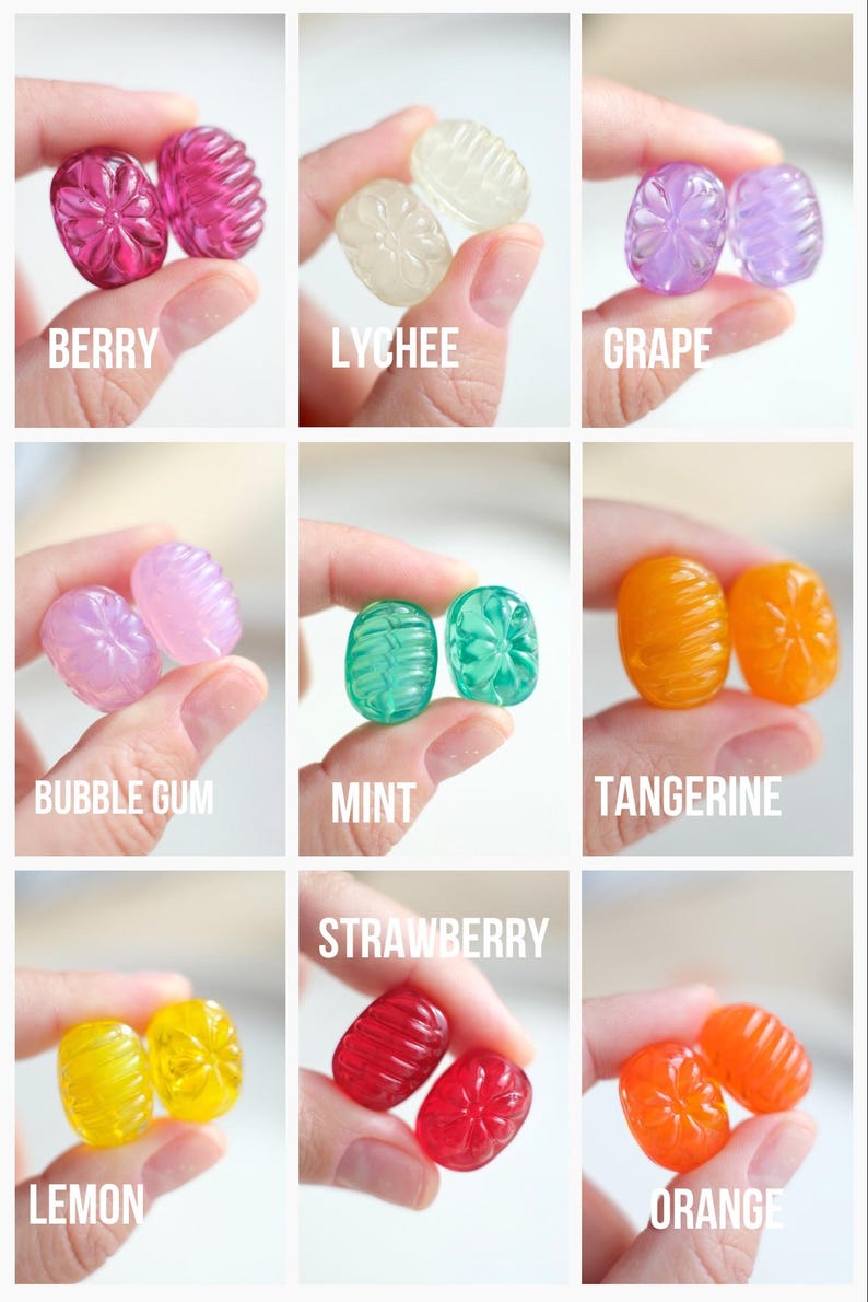 May include: A collection of colorful, jewel-toned candies in various flavors, including berry, lychee, grape, bubble gum, mint, tangerine, lemon, strawberry, and orange. Each candy is held between fingers, with the flavor name displayed below.