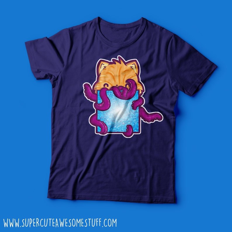 May include: A navy blue t-shirt featuring a cartoon cat with orange fur and purple tentacles emerging from a blue square. The website address www.supercuteawesomestuff.com is printed at the bottom of the shirt.