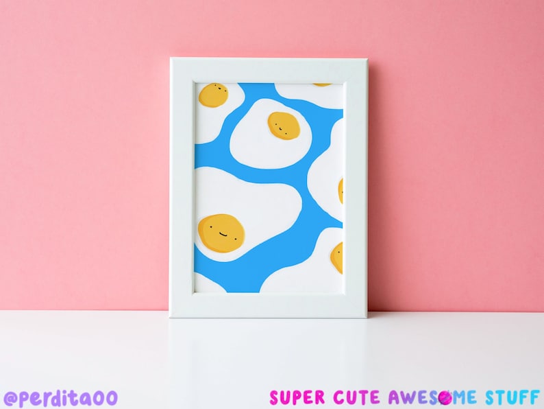 May include: A white framed print featuring a blue background with a pattern of yellow smiling fried eggs.
