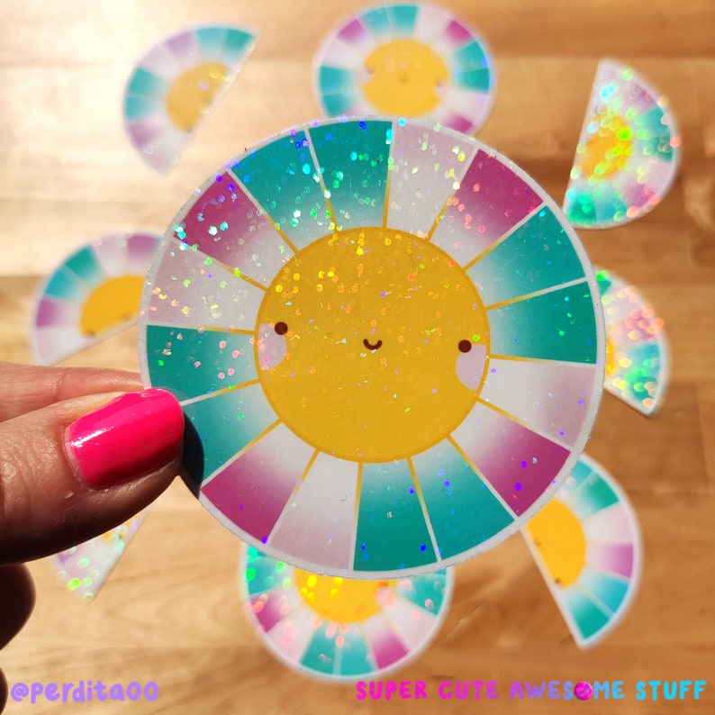 May include: A set of iridescent rainbow sun stickers with glitter. The sun has a happy face and is surrounded by a rainbow of colors. The stickers are perfect for adding a touch of whimsy to any project.