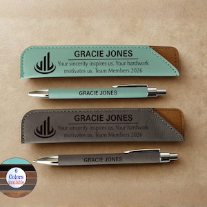 Op de afbeelding: Twee gepersonaliseerde pennen en pennenzakken. Eén pen en etui zijn zeegroen, de andere is grijs. Elke etui heeft de naam "GRACIE JONES" en de tekst "Your sincerity inspires us. Your hardwork motivates us. Team Members 2026."