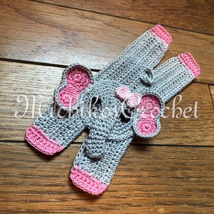 May include: Gray crocheted elephant baby booties with pink trim. The booties have a crocheted elephant face with pink ears and a pink bow.