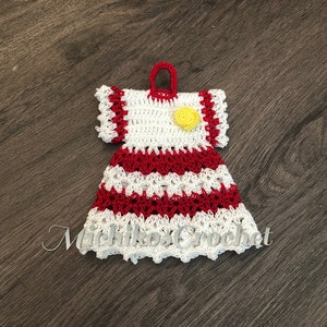 May include: A crocheted dress with red and white stripes and a yellow flower accent. The dress has a scalloped hem and a loop at the top for hanging.