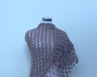 May include: A brown crocheted shawl with a delicate openwork pattern. The shawl is draped over a white dress form.