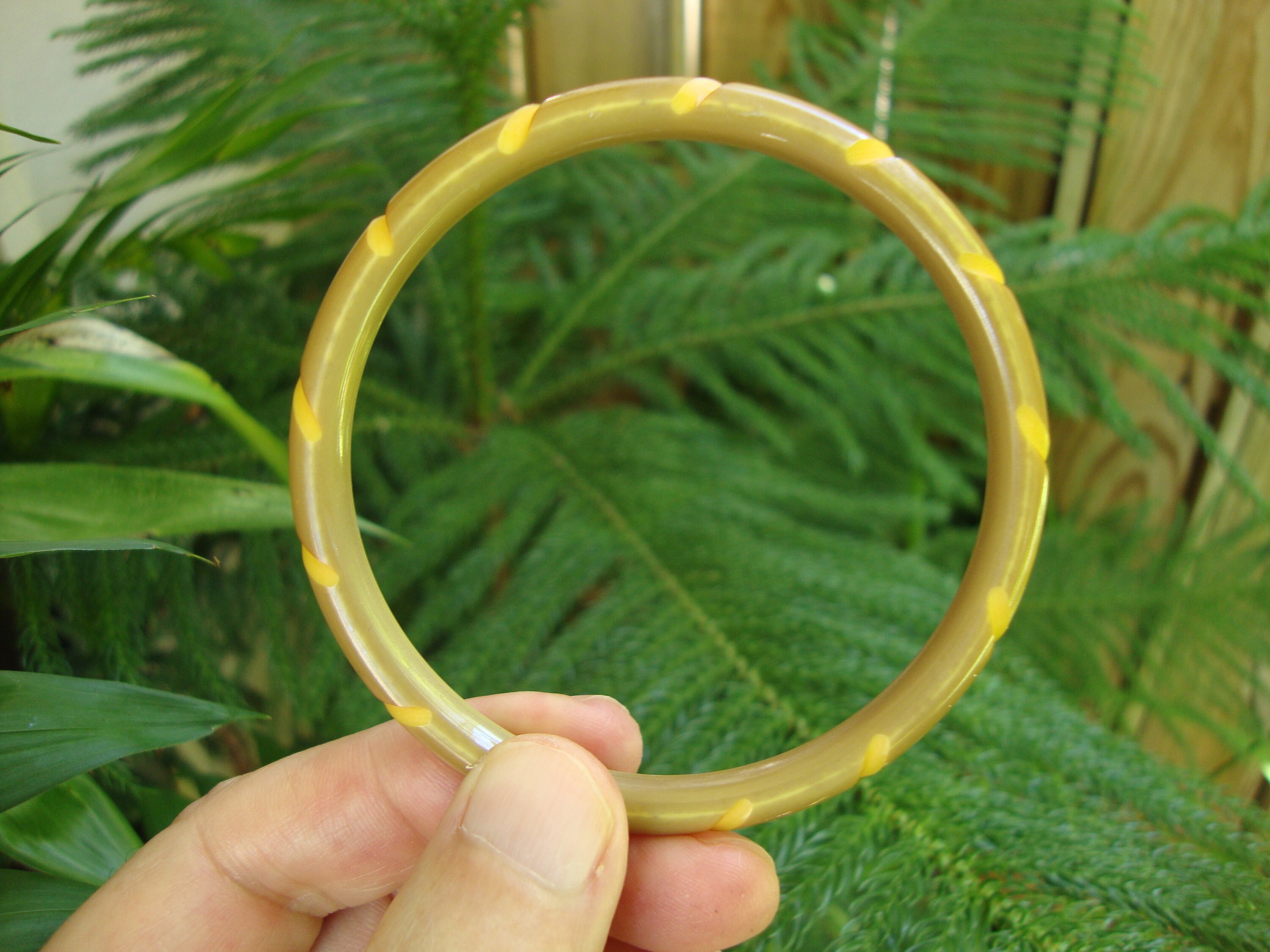 Pulsera vintage de baquelita teñida en verde caramelo. Tallas de cuerda retorcida.