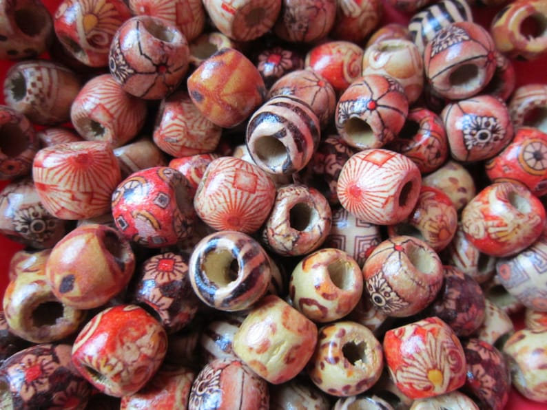 May include: A collection of wooden beads with various colorful patterns and designs. The beads are round and have a hole in the center for stringing.