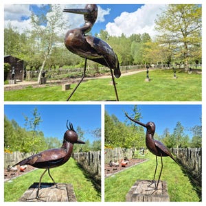 May include: Three distinct bird sculptures crafted from dark brown metal, each featuring slender wire legs and a rounded body. The figures display varied beak shapes and head crests, standing on weathered wooden blocks in an outdoor setting.