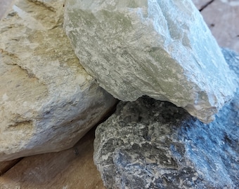 Può includere: Tre pezzi di pietra ollare naturale grezza in varie tonalità di grigio e verde. La pietra ollare è un materiale popolare per l'intaglio e la scultura.