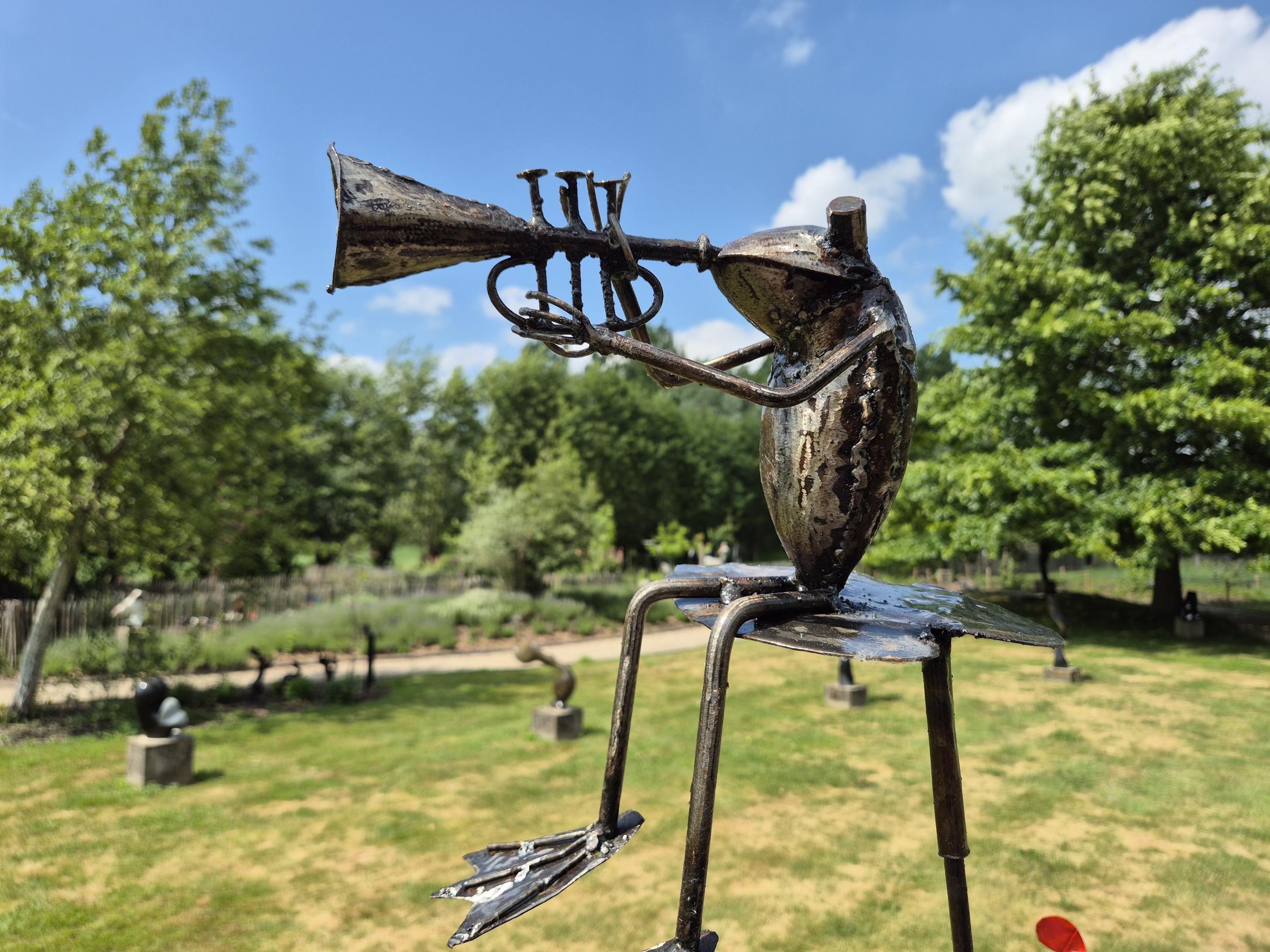Frog sculptures on a stick, frog orchestra, different music instruments,  unique and whimsical garden sculpture, made from oil drums