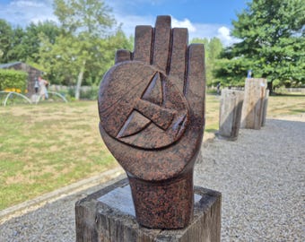 stone sculpture, hand holding a face, made in a colourful serpentine stone, shona art statue, unique piece, spiritual meaning