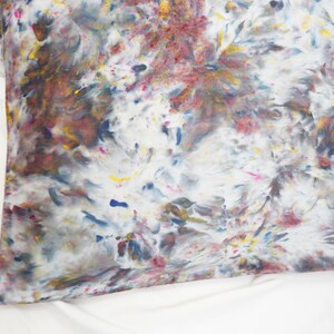 May include: A white pillowcase with a colorful tie-dye pattern in shades of blue, pink, yellow, and brown.