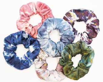 Może przedstawiać: Sześć kolorowych scrunchie wykonanych z tkaniny z wzorami tie-dye. Scrunchie są w odcieniach niebieskiego, zielonego, różowego i białego.