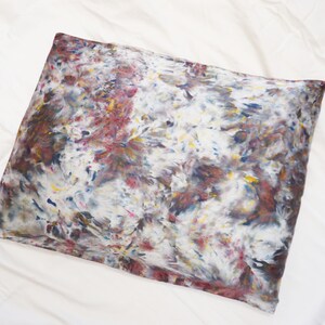 May include: A pillowcase with a tie-dye pattern in shades of brown, blue, yellow, and red.