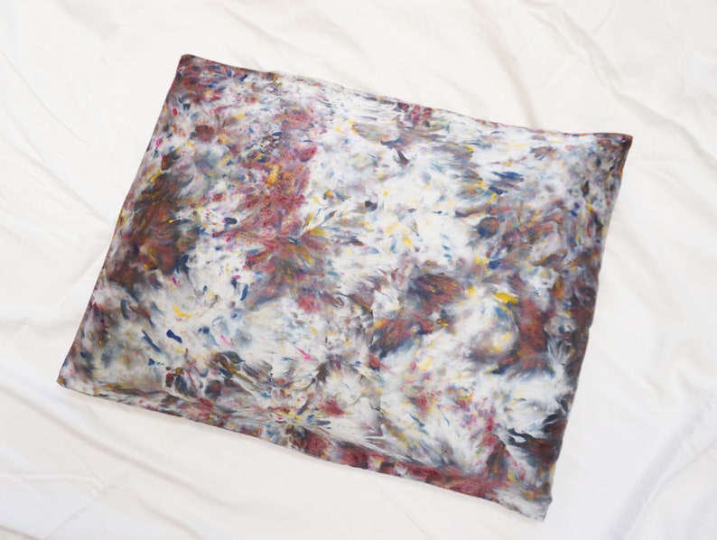 May include: A pillowcase with a tie-dye pattern in shades of brown, blue, yellow, and red.