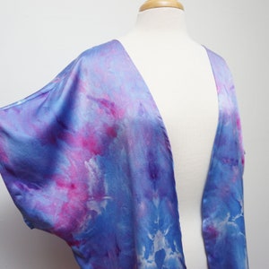 May include: A blue and pink tie-dye silk kimono with a deep V-neckline.