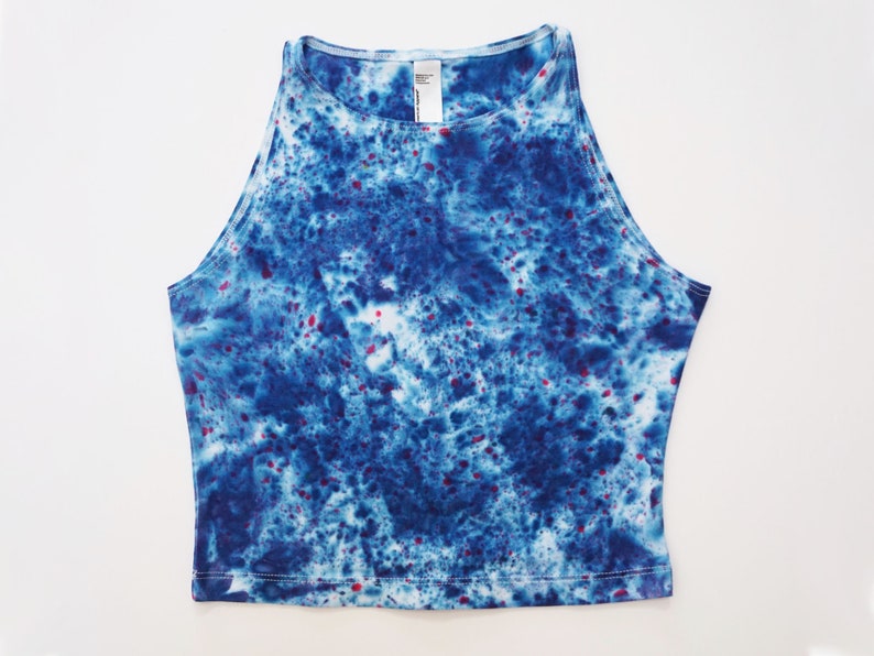 May include: A blue and white tie-dye crop top with red speckles.