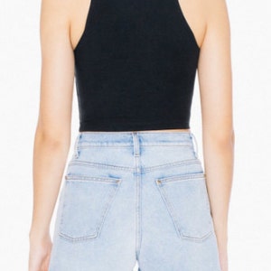 May include: A black cropped tank top with a racerback style. The tank top is made of a soft, stretchy fabric and has a relaxed fit.