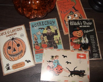 May include: A collection of five rectangular Halloween-themed paper prints featuring vintage-style illustrations. Designs include a Jack-O-Lantern candle label, a scarecrow, a Witch's Brew cider mix label, a pumpkin carriage, and a cat-themed sign.