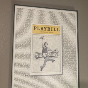 May include: A Playbill for the musical "Newsies" at the Nederlander Theatre. The Playbill features a black and white image of a newsboy running with a newspaper in hand. The Playbill also includes text about the show and its cast.