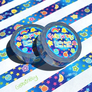 May include: Two rolls of doodle washi tape with a blue and white striped background. The tape features a repeating pattern of stars, rainbows, and cartoon fruits. The tape is 1.5cm x 10m.