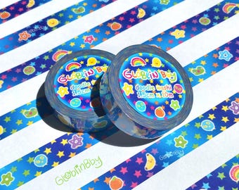 May include: Two rolls of doodle washi tape with a blue and white striped background. The tape features a repeating pattern of stars, rainbows, and cartoon fruits. The tape is 1.5cm x 10m.