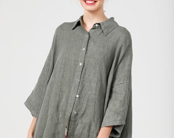 May include: A loose-fitting, green linen shirt with a collared neckline and button closure. The shirt has a relaxed fit and a slightly longer length in the back.