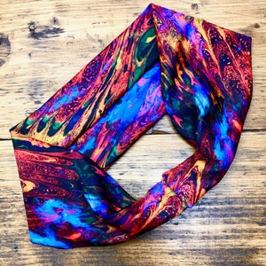 May include: A colorful headband with a marbled pattern in shades of red, blue, yellow, and black.