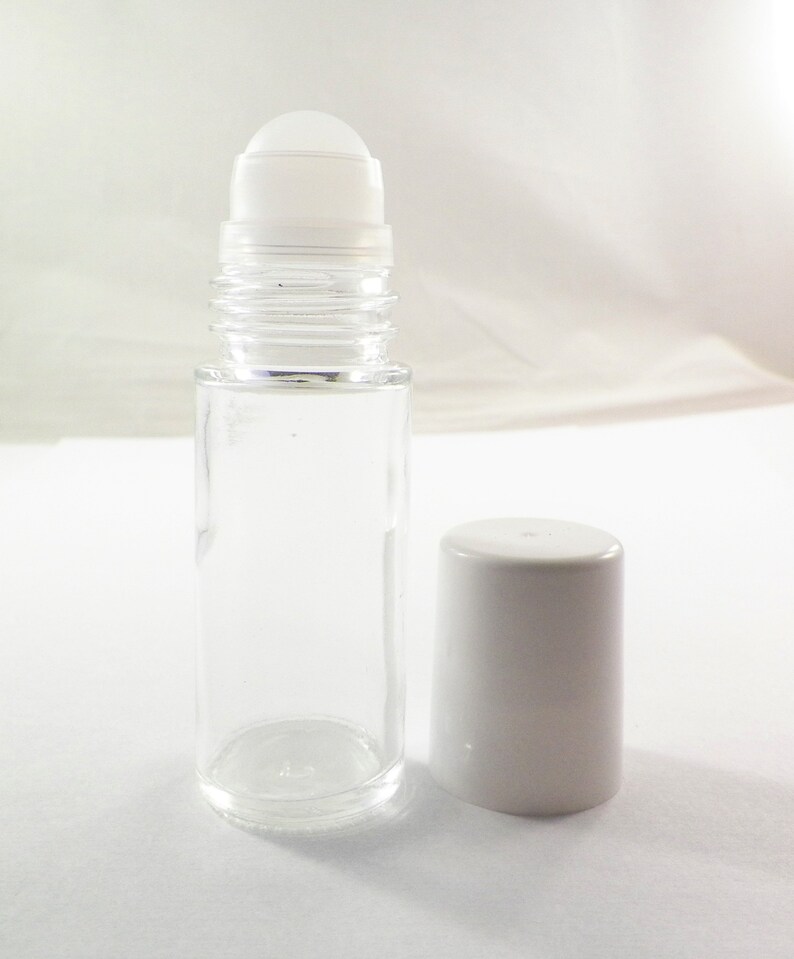 K&ouml;nnte beinhalten: Eine klare Glas-Rollflasche mit einem wei&szlig;en Kunststoff-Rollball und einem wei&szlig;en Kunststoffdeckel. Die Flasche ist leer.