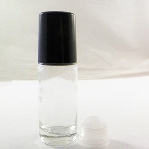 K&ouml;nnte beinhalten: Eine klare Glas-Rollflasche mit schwarzem Verschluss und einer wei&szlig;en Rollkugel. Die Flasche ist leer und bereit, mit &auml;therischen &Ouml;len oder Parf&uuml;m gef&uuml;llt zu werden.