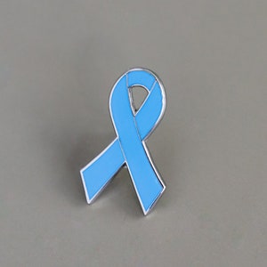 May include: A light blue ribbon pin, a symbol of awareness and support.