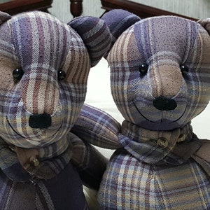May include: Two plush teddy bears made from plaid fabric in shades of brown, purple, and white. The bears have black button eyes and black noses.