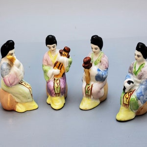 Four Chinese miniature porcelain figures of four woman musicians, each playing  on a different musical instrument