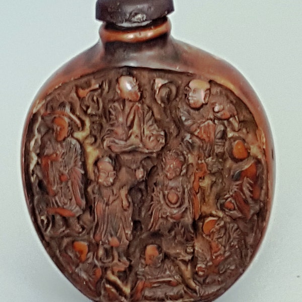vintage Chinese dark brown cinnabar snuff bottle with an emboss of  Chinese people on it.