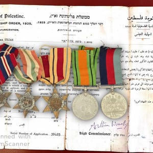 Puede incluir: Documento histórico de Palestina con medallas y retrato. El documento, fechado en 1925, presenta textos en inglés, hebreo y árabe. Se muestran varias medallas con cintas de colores.