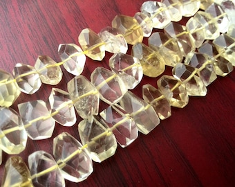 May include: A strand of faceted, clear, yellow citrine gemstone beads. The beads are strung on a thin wire and are all approximately the same size and shape.