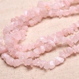 May include: A strand of pink rose quartz chip beads. The beads are irregular in shape and size, and have a natural, unpolished finish.