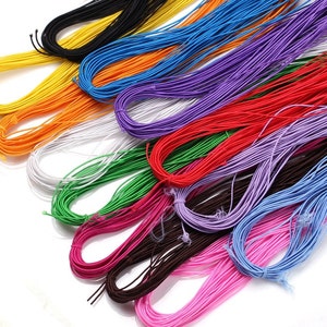Puede incluir: Una colección de cordones coloridos en varios tonos, incluyendo amarillo, naranja, blanco, verde, rosa, rojo, morado, azul y negro. Estos cordones están enrollados firmemente y parecen estar hechos de un material flexible, adecuado para manualidades o joyería.
